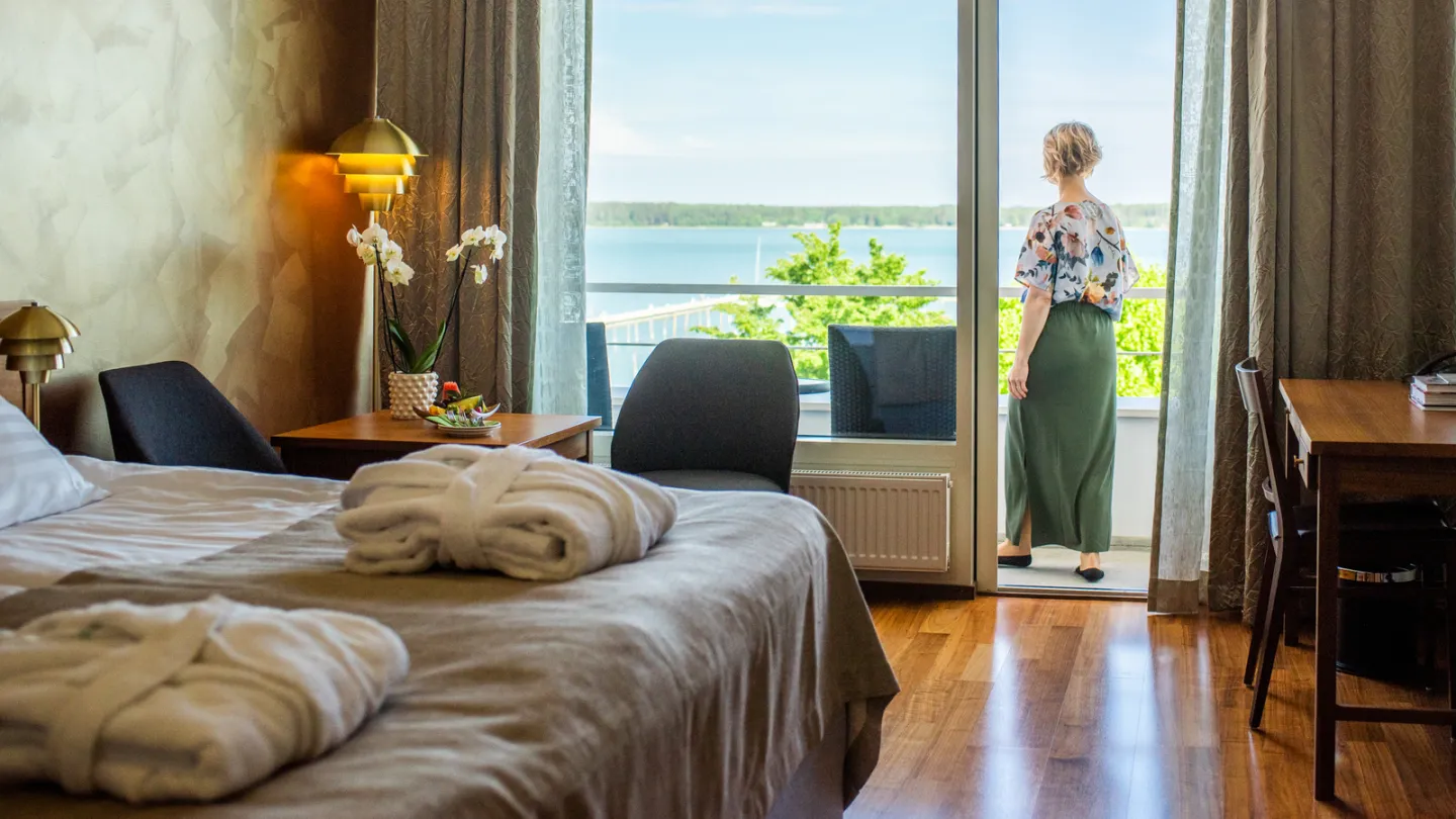 Interiören från ett hotellrum där man skymtar havet från balkongen